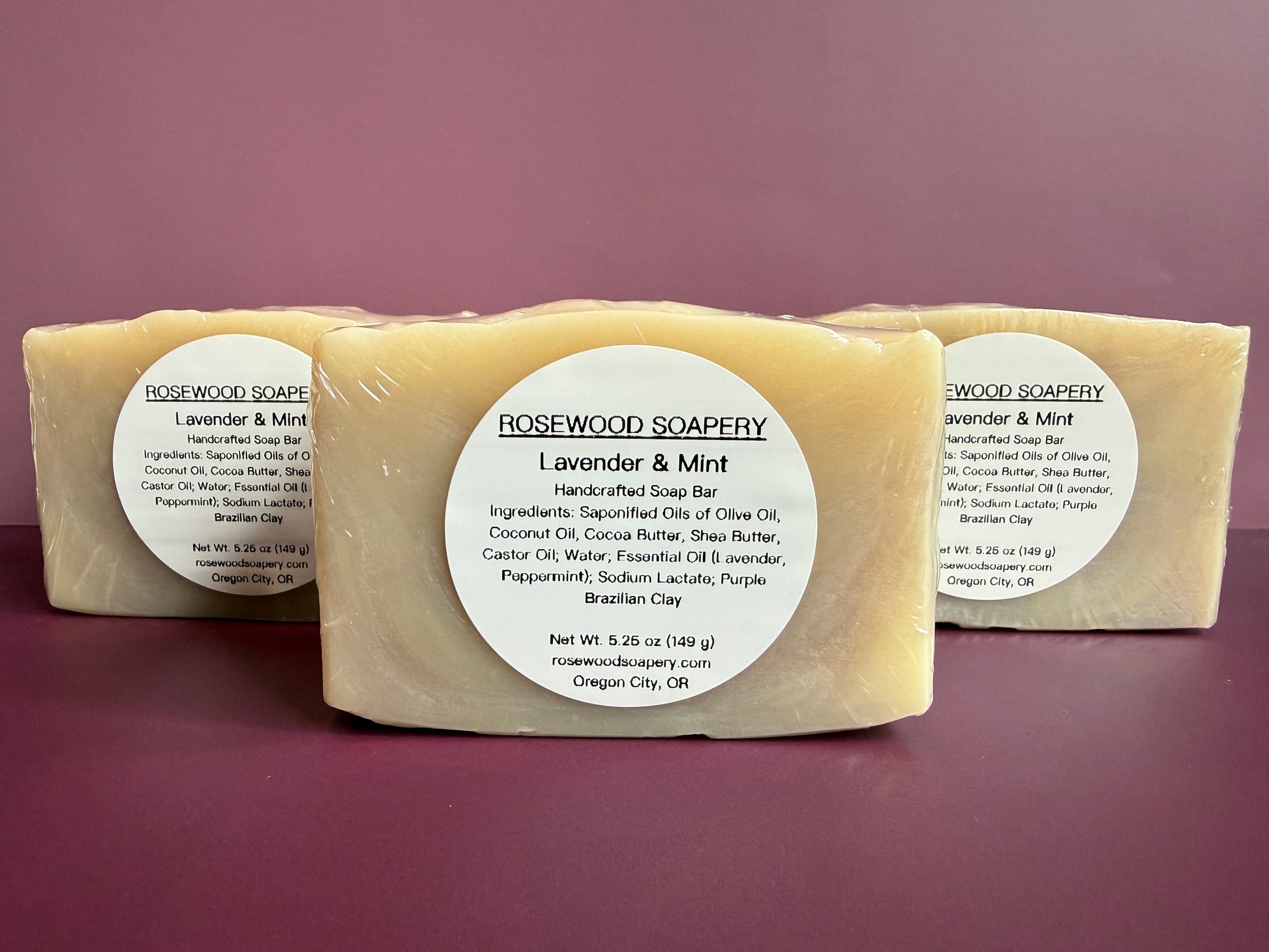 Three bars of soap from Rosewood Soapery on a purple background