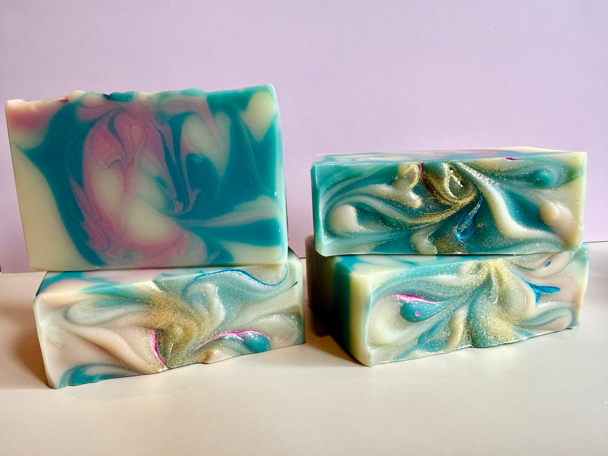 Four bars of pink and blue swirled soap. 