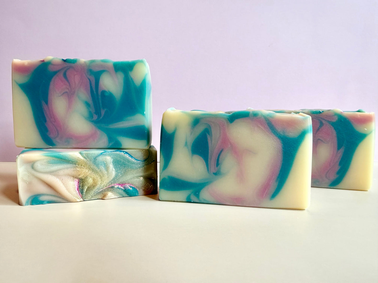 Four bars of pink and blue swirled soap. 