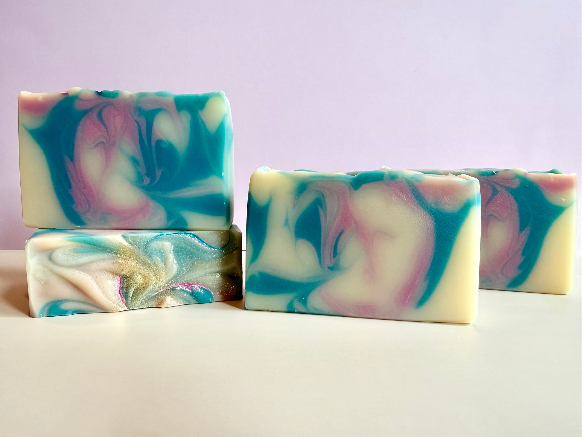 Four bars of pink and blue swirled soap. 