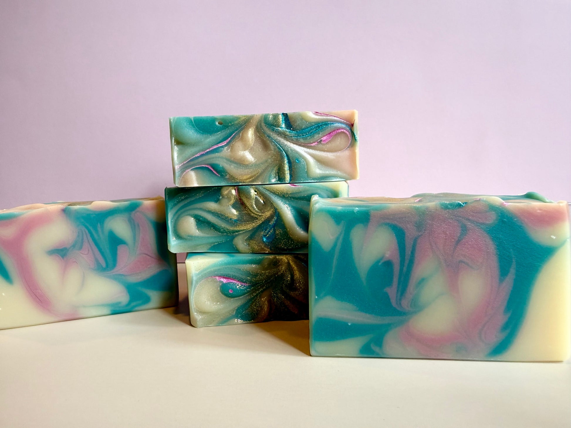 Four bars of pink and blue swirled soap. 